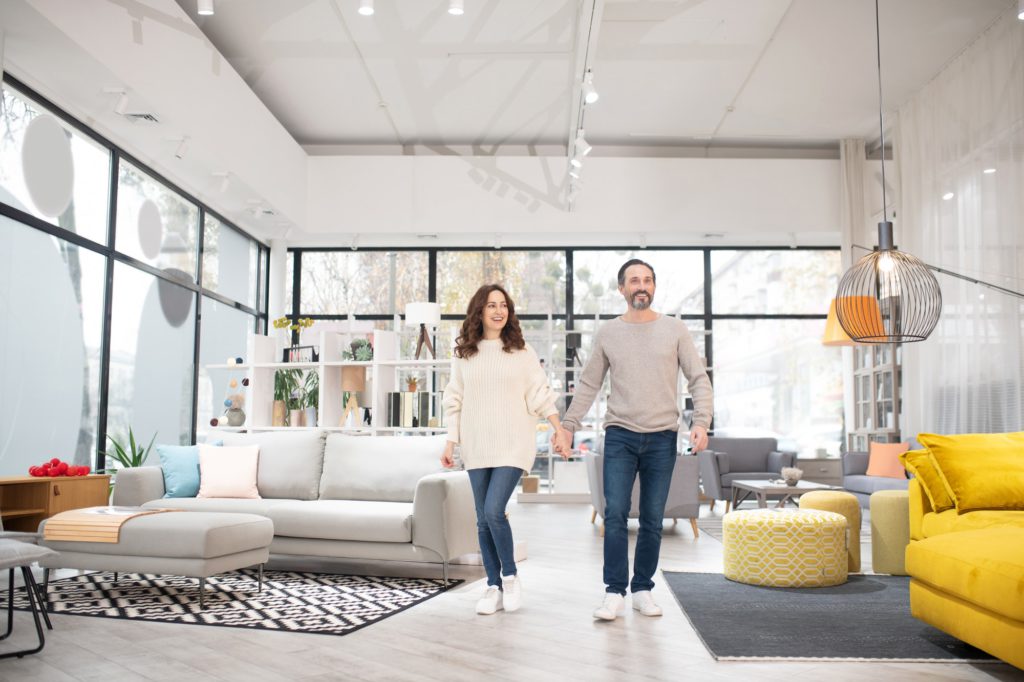 Two people looking at furniture models in a modern furniture shop